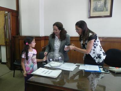 De izquierda a derecha: Niña integrante de una de las familias inscriptas, Mabel Rivero (Mercado Inmobiliario) y la Esc. María Adriana Costa.