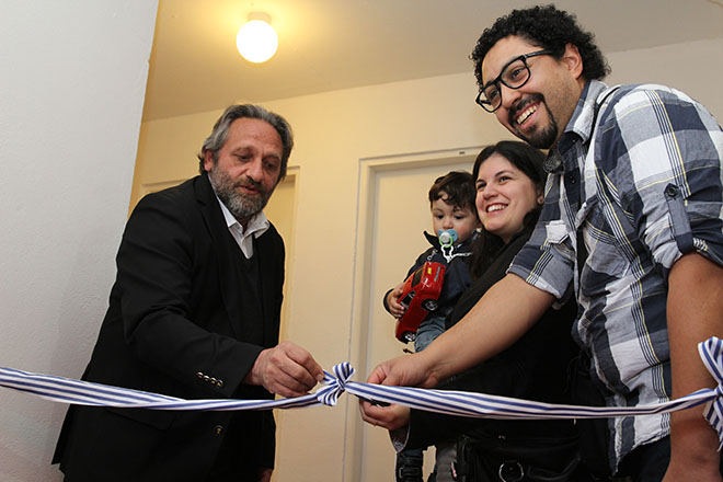El Ministro de Vivienda, Arq. Francisco Beltrame, desatando la cinta inaugural junto a algunos de los nuevos propietarios.