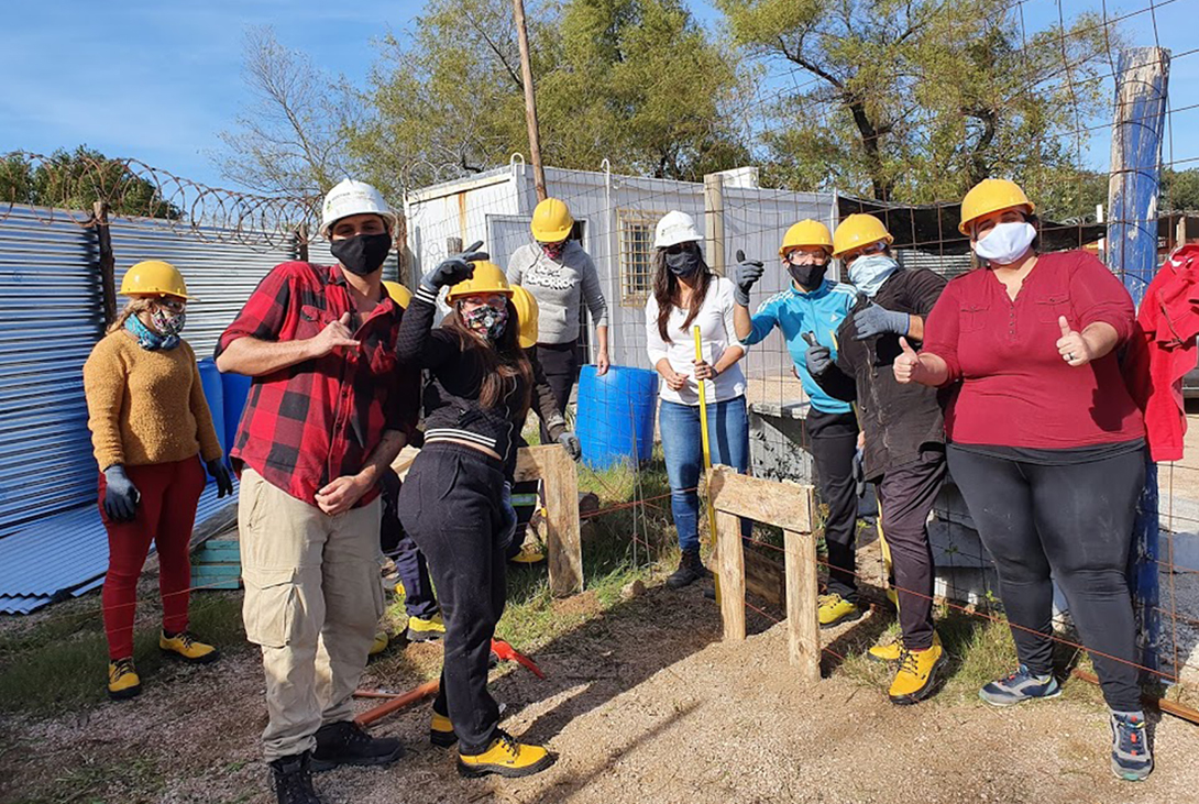 Ocho cooperativistas posando en una construcción.