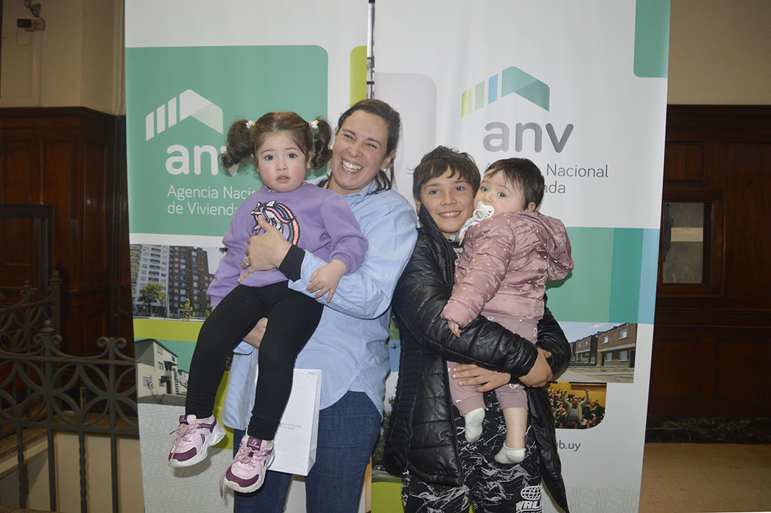 María y sus tres hijos recibiendo las llaves de su vivienda