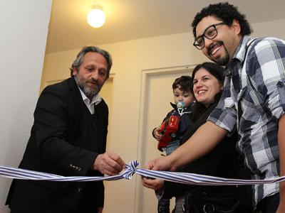 El Ministro de Vivienda, Arq. Francisco Beltrame, desatando la cinta inaugural junto a algunos de los nuevos propietarios.