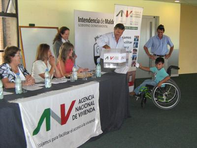 De izquierda a derecha: A.S. Cristina Fynn (Presidenta ANV), Ana Muñiz (Gerenta de la Oficina Técnica de Maldonado), Escribana Silvia Alzugaray, Mabel Rivero (Mercado Inmobiliario), Jorge Queiroz (Gerente División Sucursales) y beneficiarios de la Categoría Capacidades Diferentes.