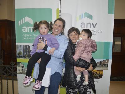 María y sus tres hijos recibiendo las llaves de su vivienda