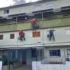 Obreros pintando fachada de viviendas